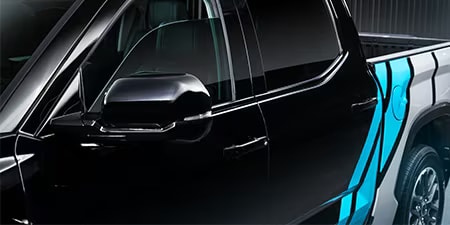 Details of a bright blue and white accent wrap on a black pickup truck.
