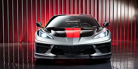 Red and black partial wrap on the hood of a gray coupe.
